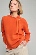 Orange pullover with bow trim