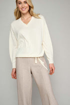 Ecru pullover with V-neck and detail 