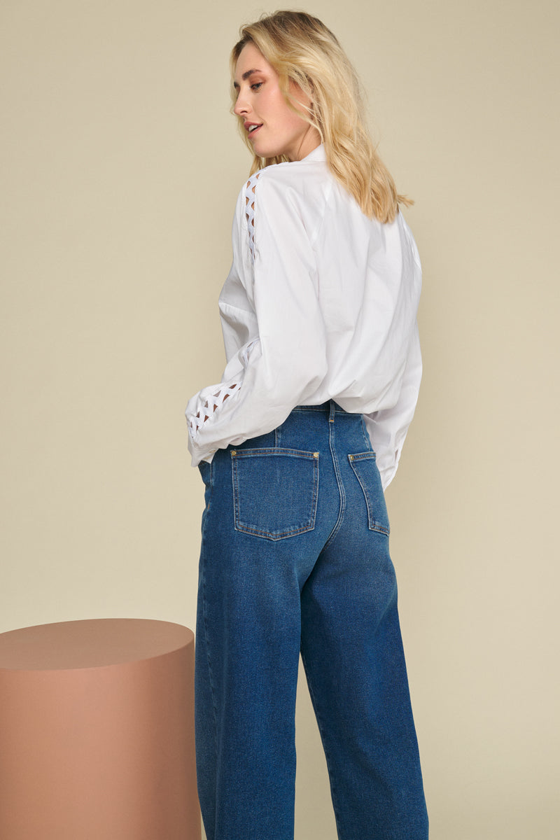 Blouse blanche avec un beau motif au crochet sur les manches