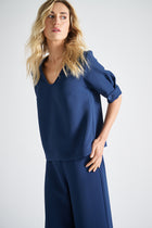 Chemisier bleu à col en V et manches joliment finies