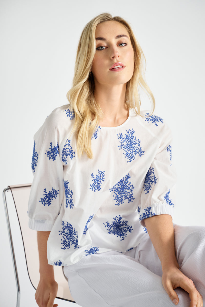 Witte bloes met geborduurde blauwe bloemen