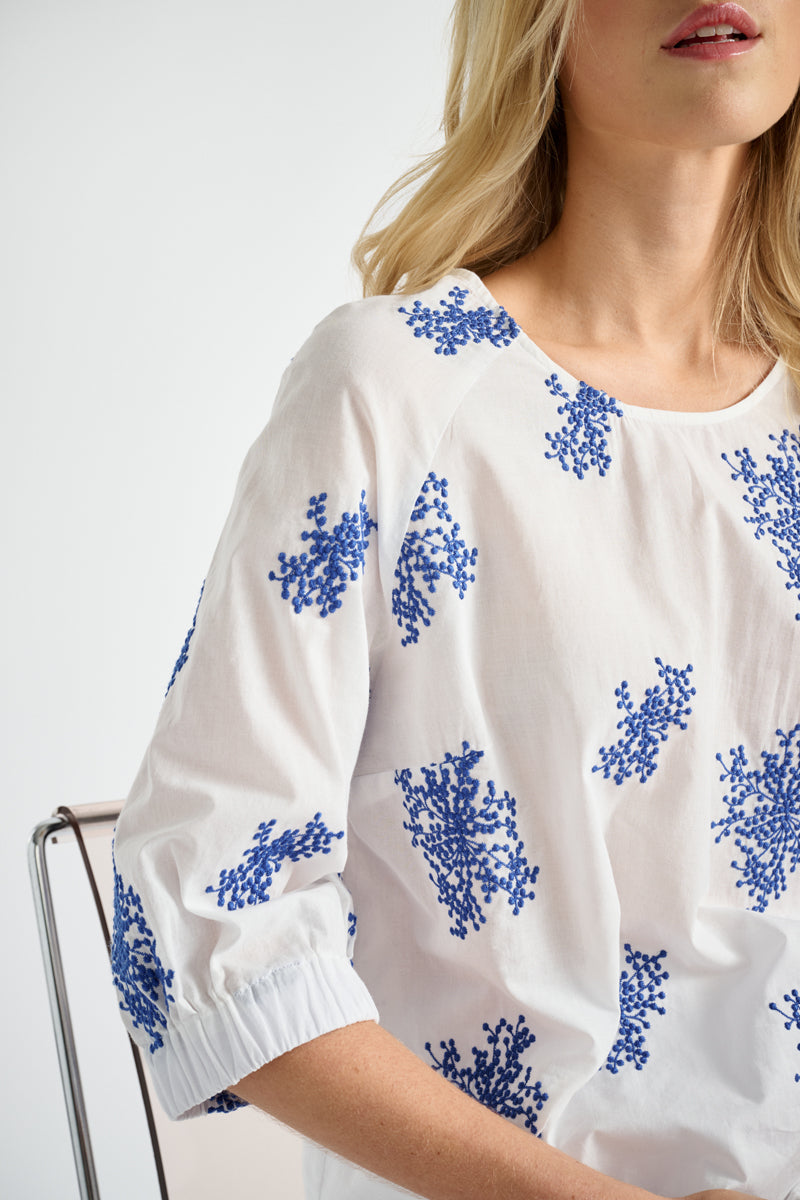 Witte bloes met geborduurde blauwe bloemen