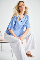 Lichtblauwe bloes met broche aan de hals