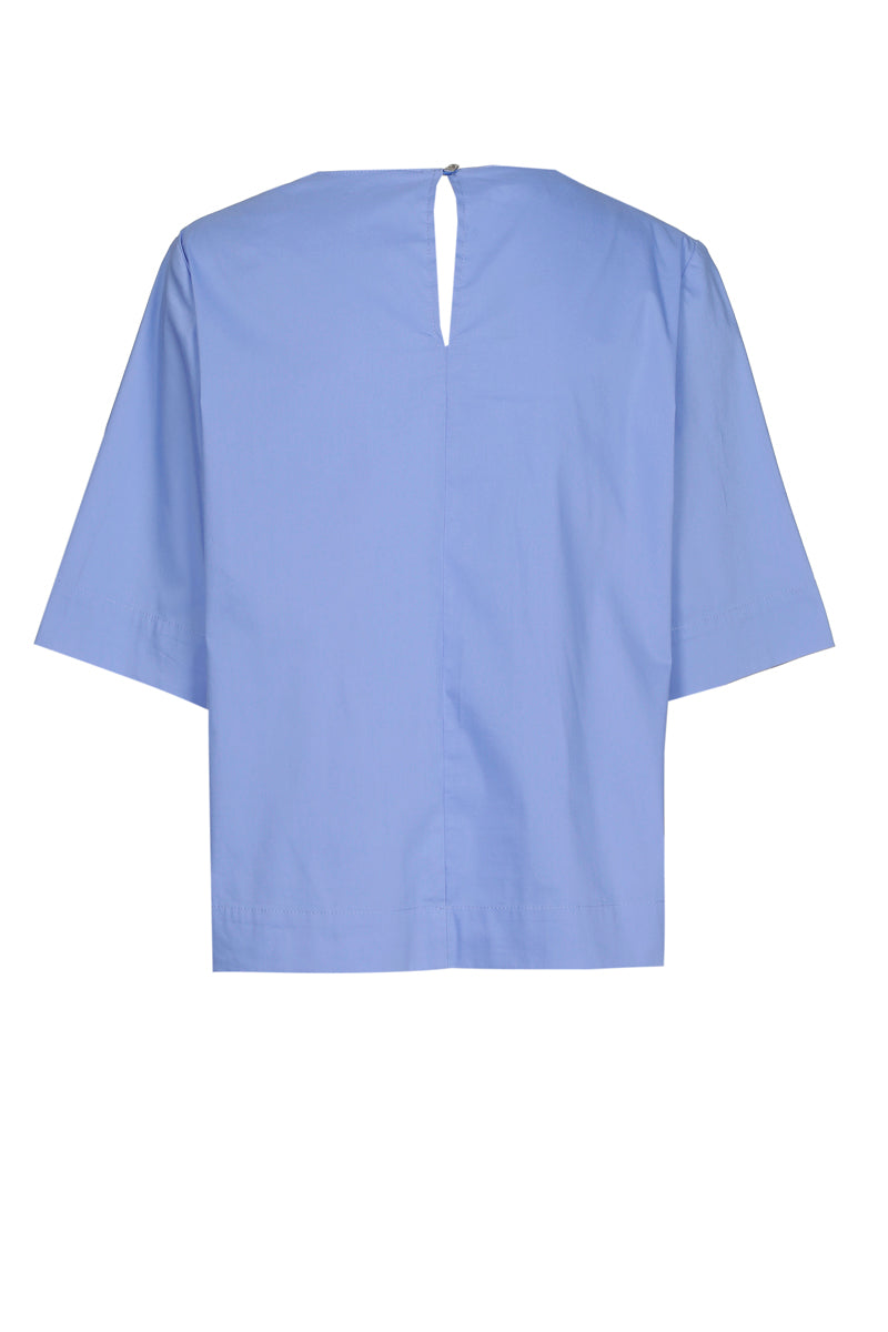 Lichtblauwe bloes met broche aan de hals