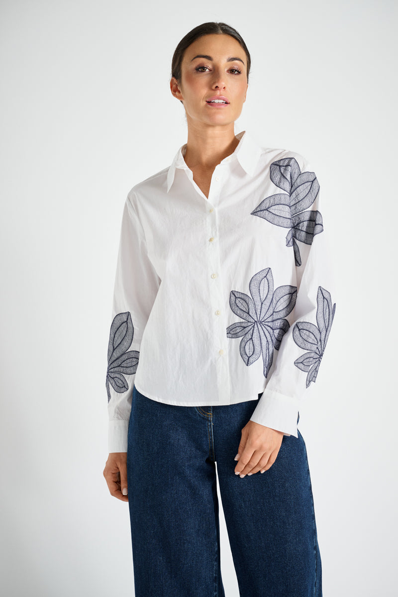 Chemisier blanc avec fleur bleue