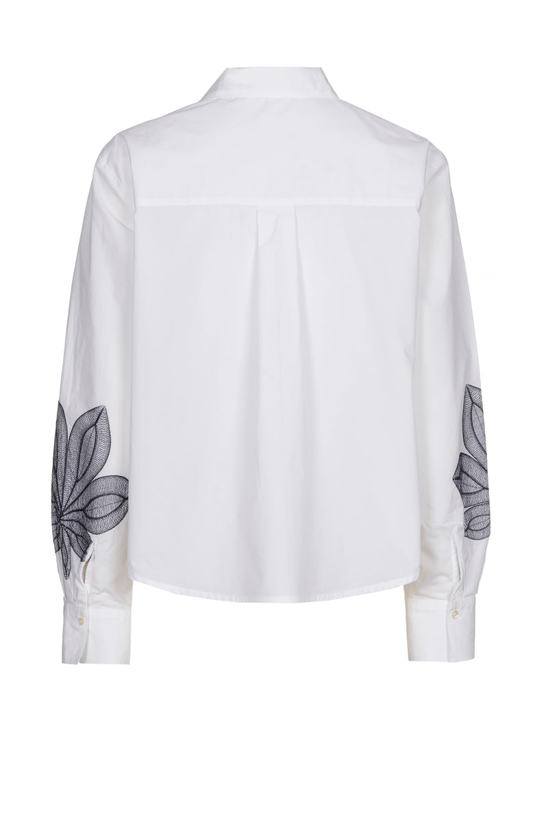 Chemisier blanc avec fleur bleue