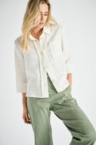 Crèmekleurige bloesjas met kraag en knopen